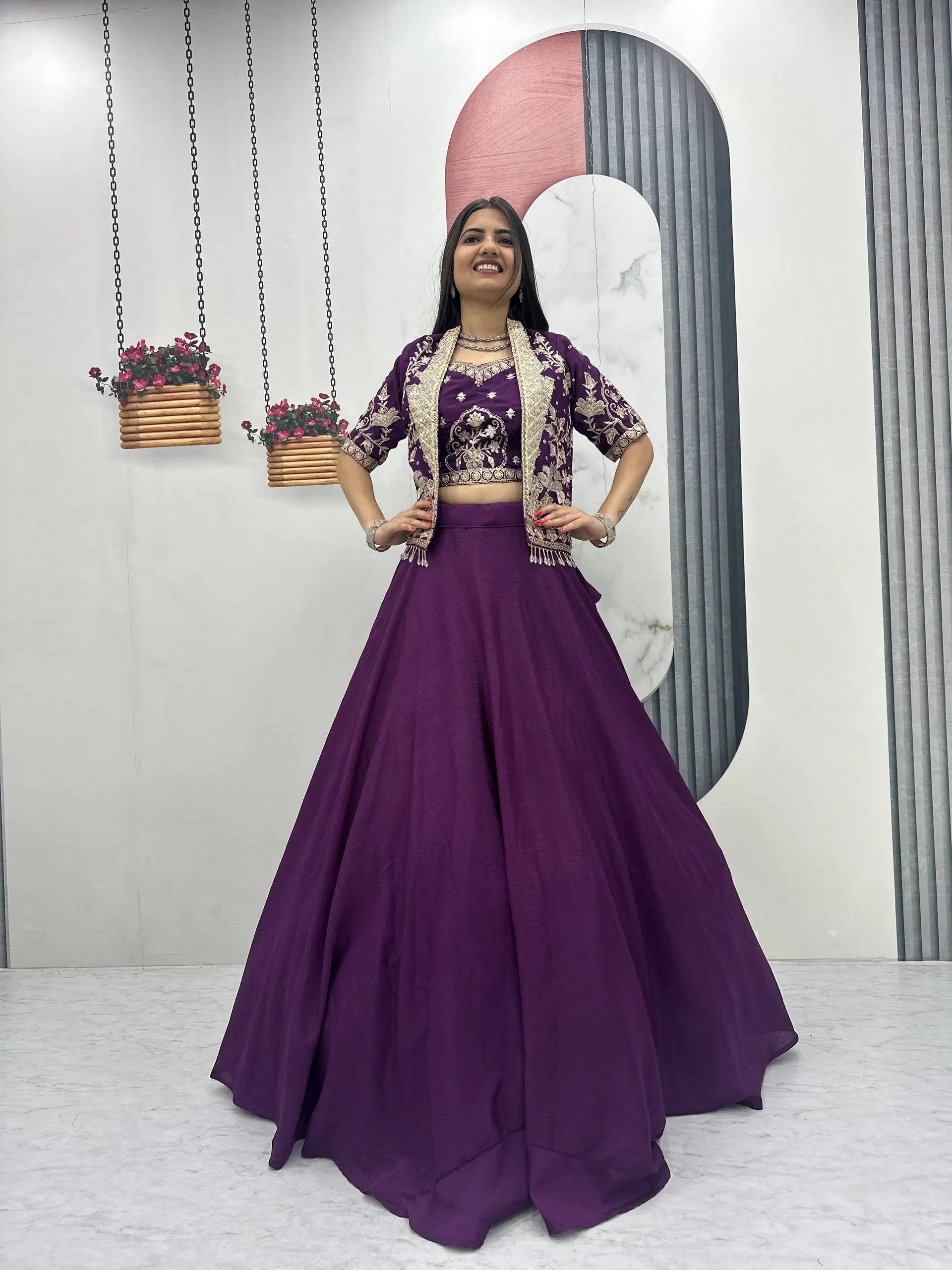 Woman in a purple traditional outfit posing in a studio setting.