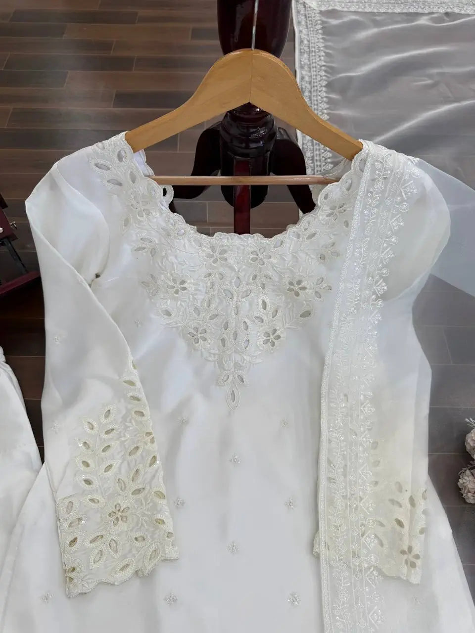 White lace top on a wooden hanger with a blurred background
