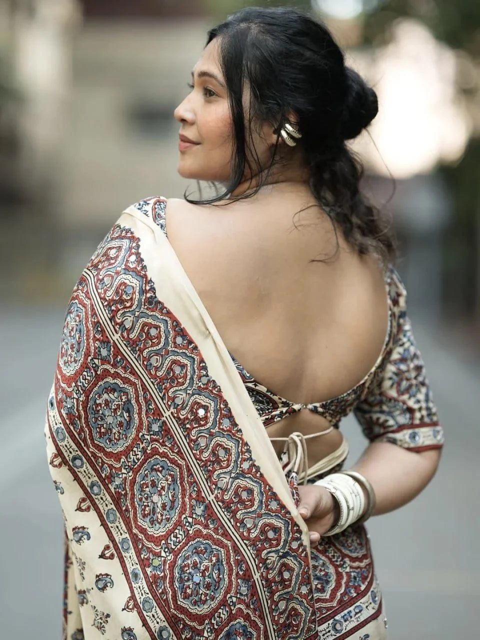 back view of cream ajrakh modal silk saree with printed pallu and mirror work