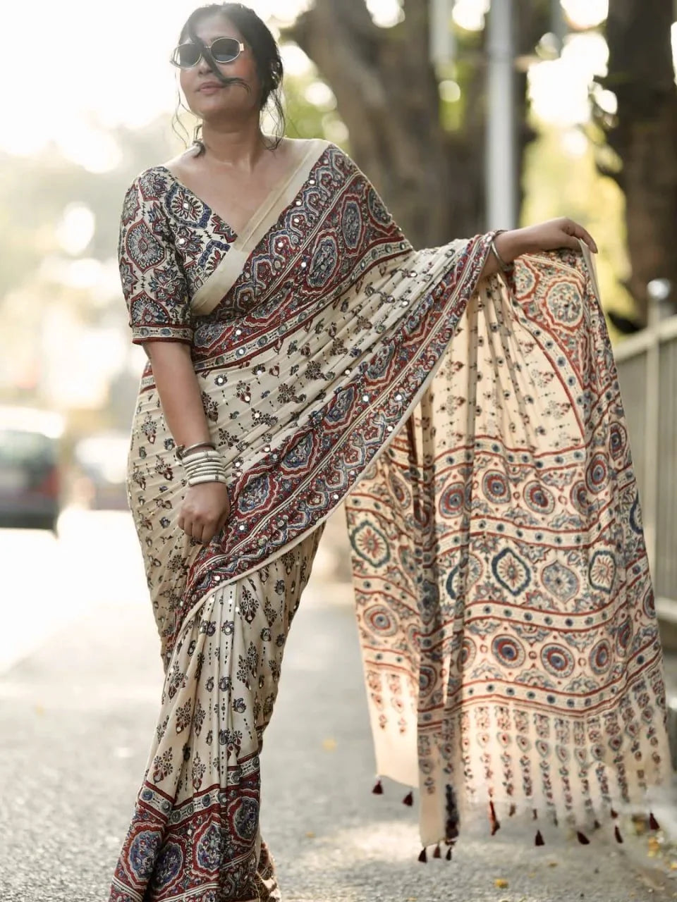 close up of cream ajrakh modal silk saree pallu mirror work and floral print