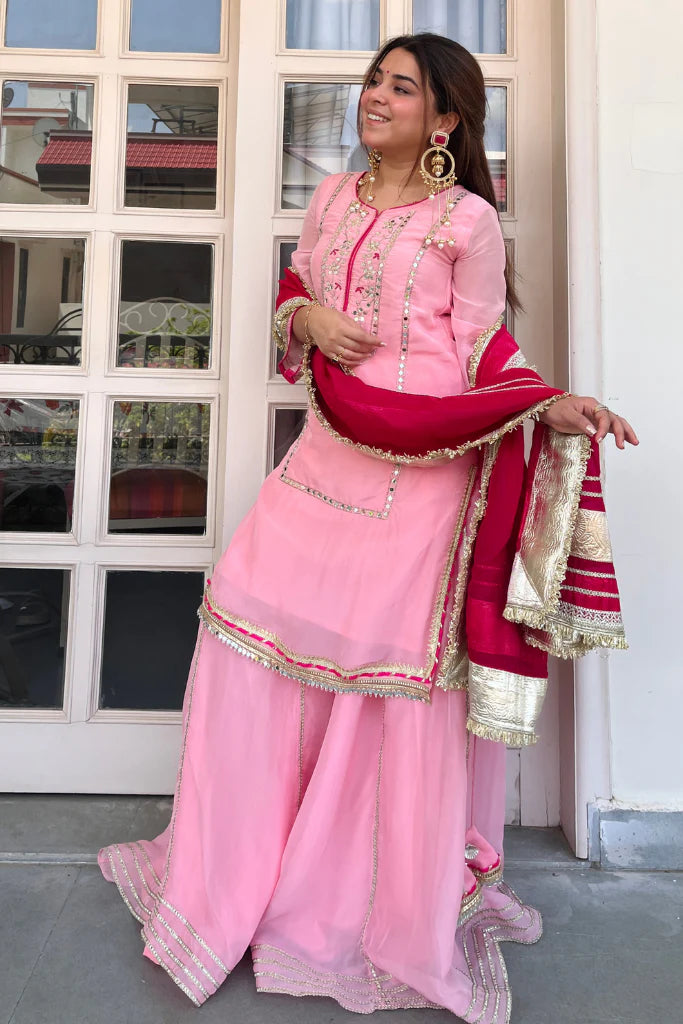 Full front view of baby pink organza silk sharara set with sequin zari embroidery and maroon dupatta
