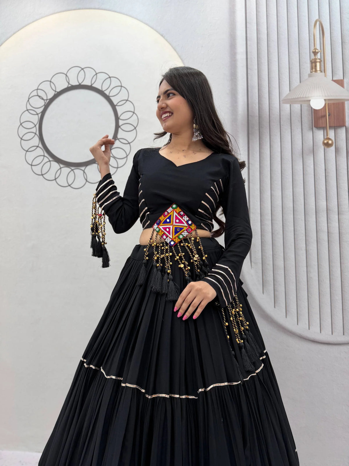 Black navratri lehenga choli with mirror work waist belt and tassel latkans front