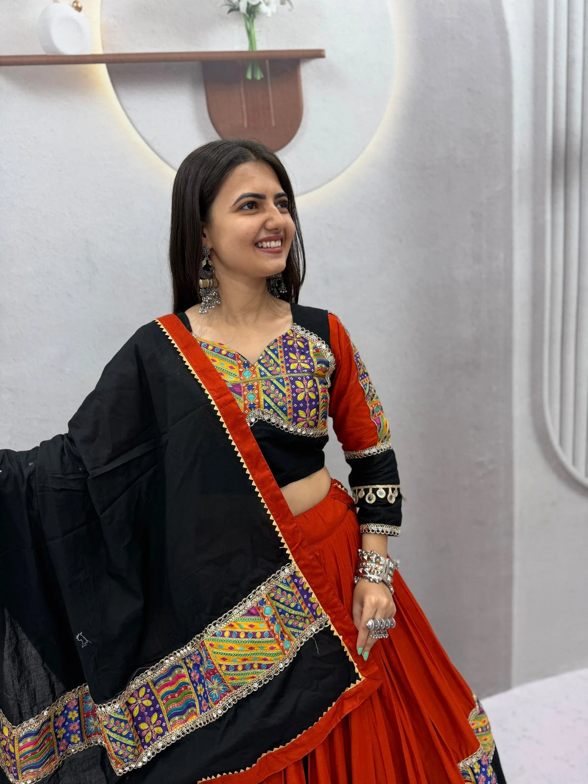 Orange and black cotton navratri chaniya choli with Kutchi mirror-work choli and black dupatta - front view