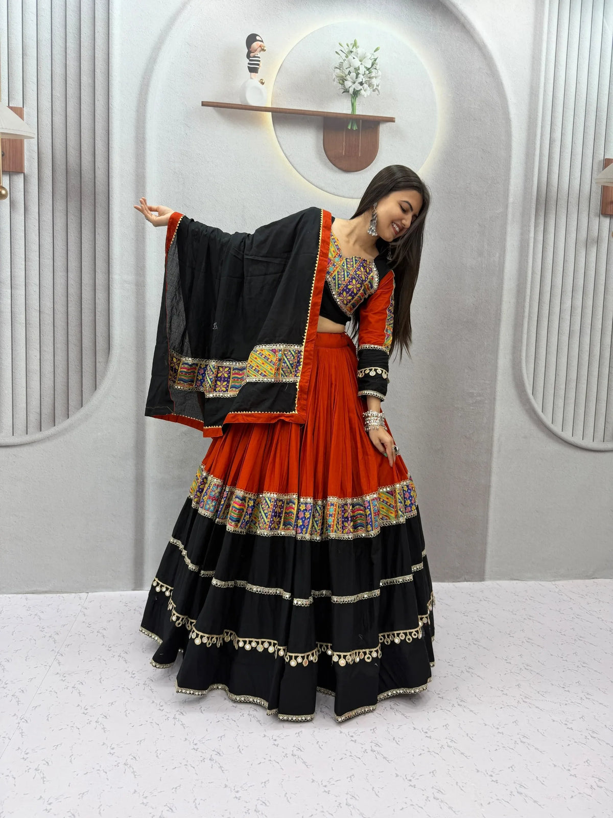 Cotton navratri chaniya choli with 6-metre orange and black tiered flair spread - seated twirl