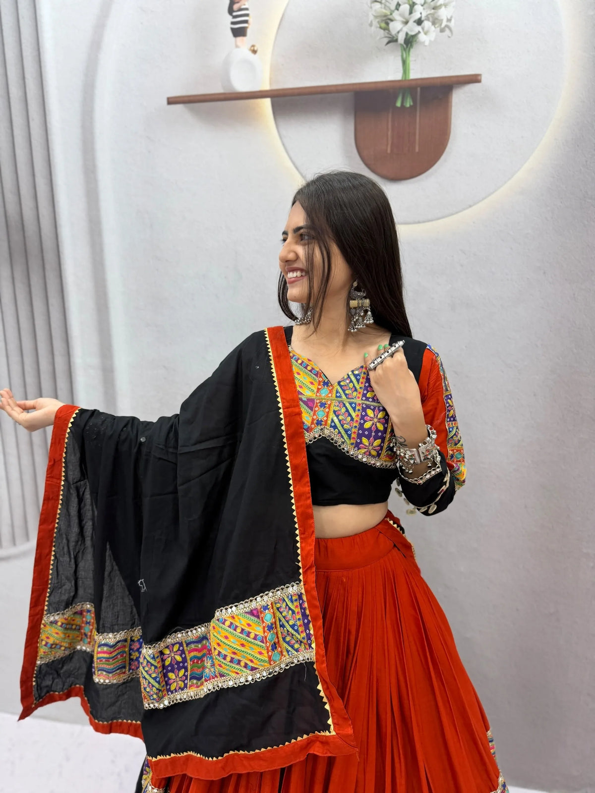 Cotton navratri chaniya choli with black mirror choli, orange skirt and black dupatta - side pose