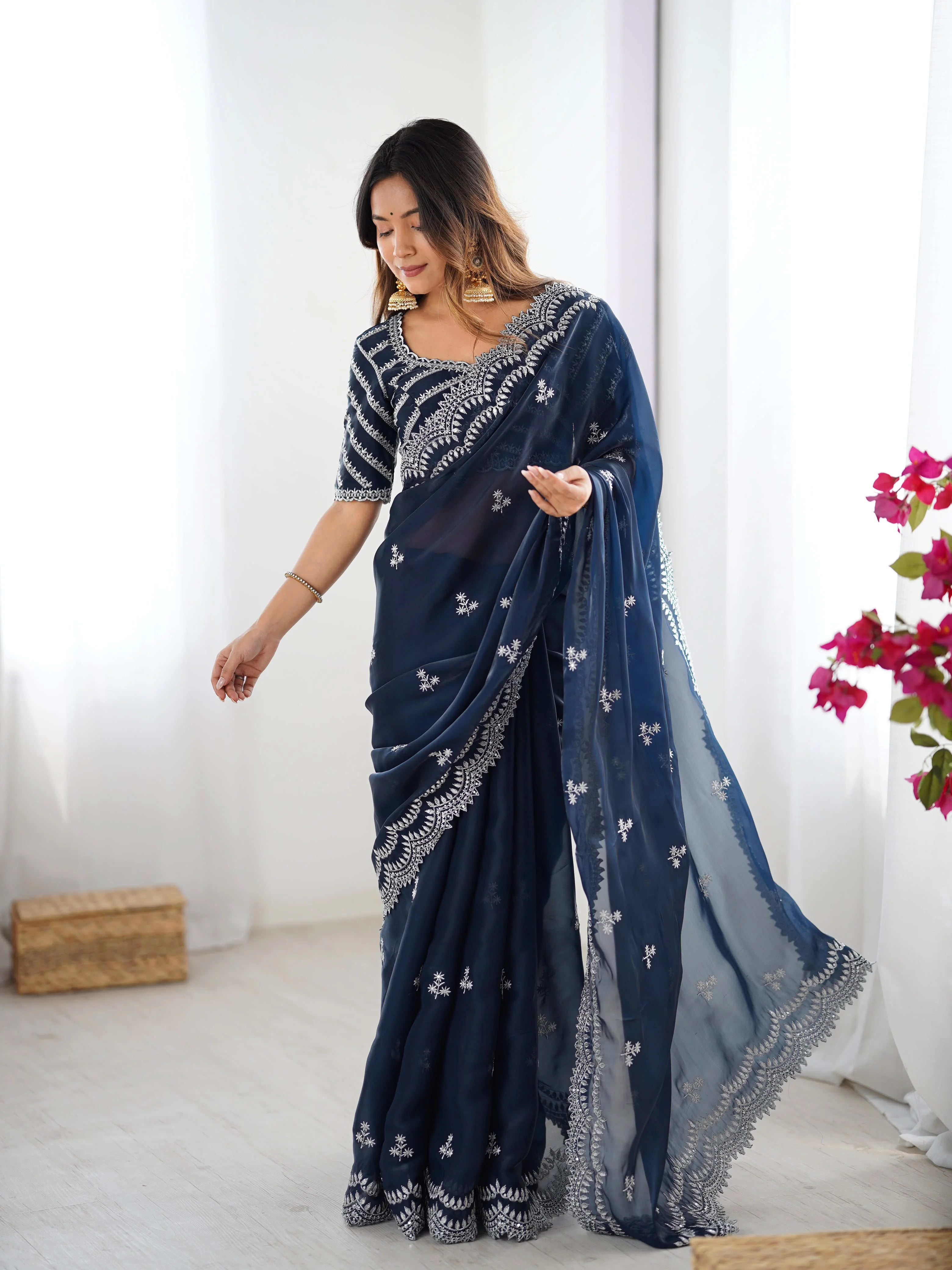 Yellow faux georgette saree — model holding pallu scalloped embroidery detail visible
