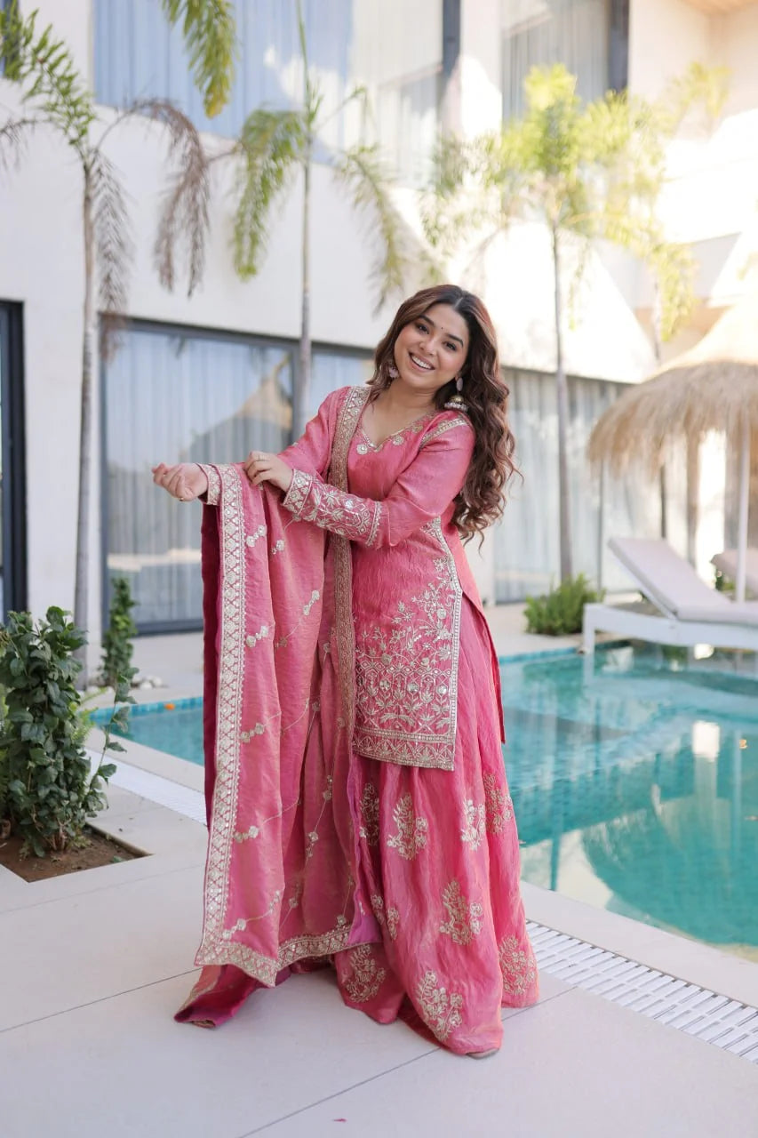 Peach fendi crush sharara set with zari sequin dupatta standing poolside