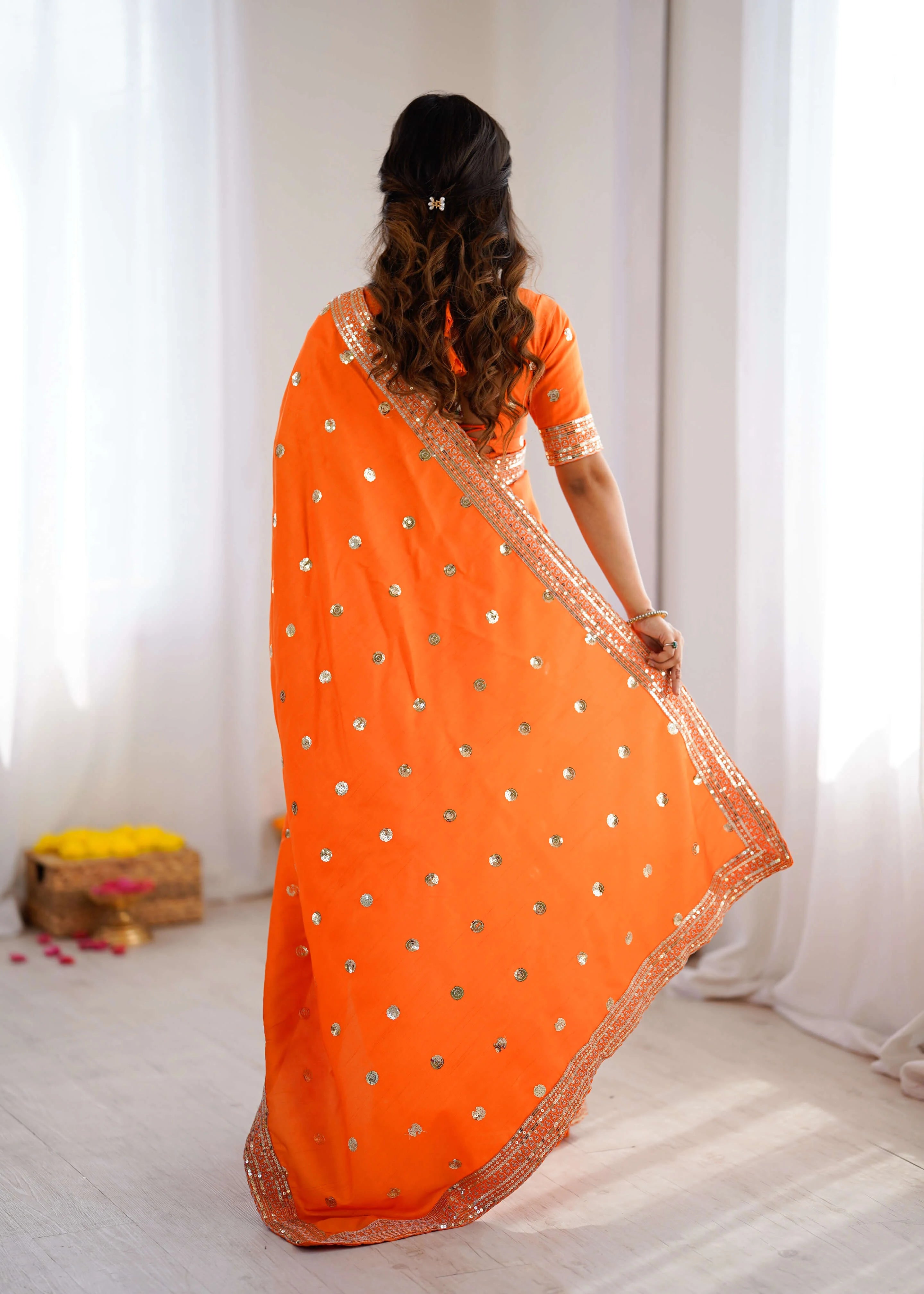 Heavy georgette sequin saree in orange back view showing full drape