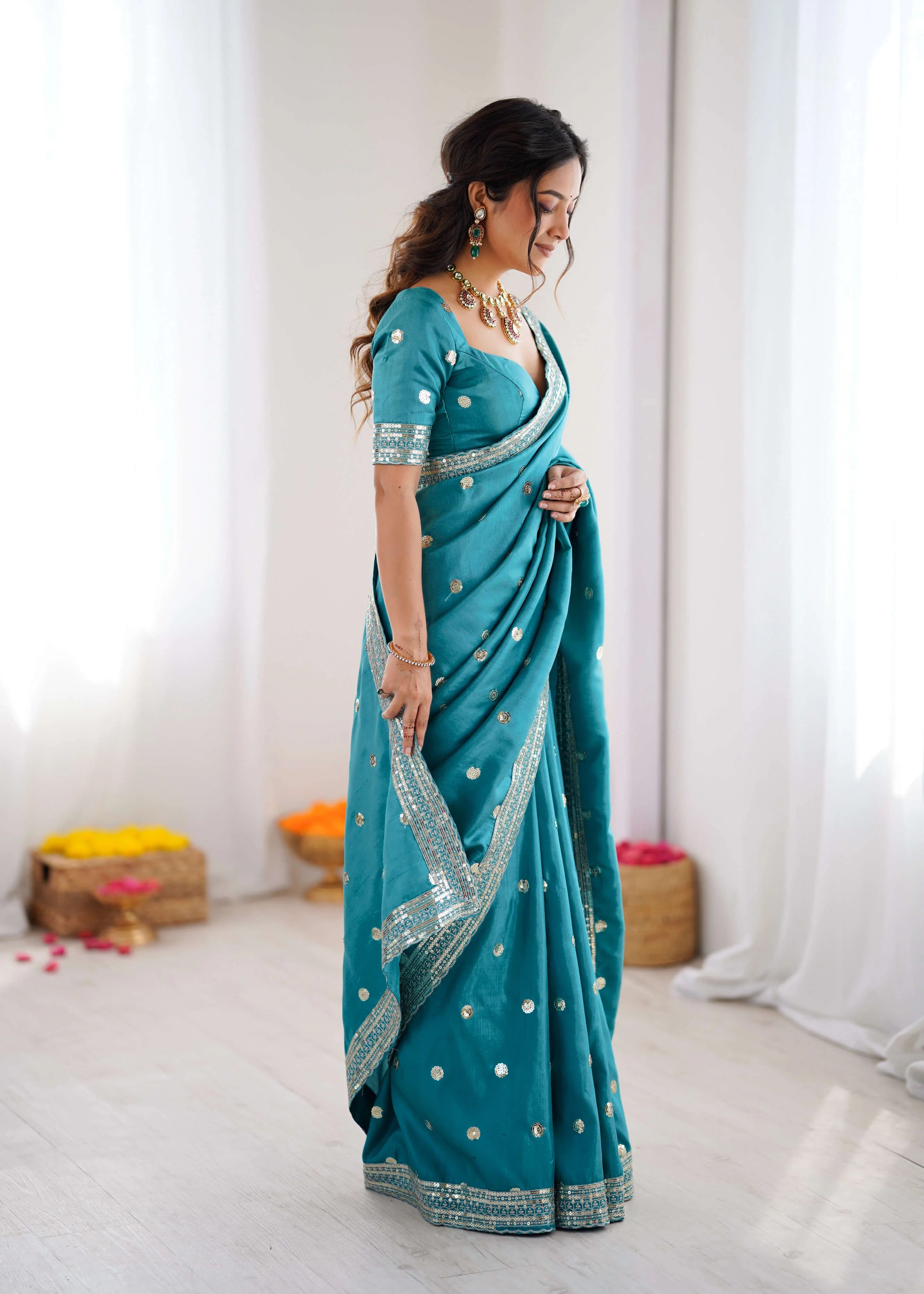 Heavy georgette sequin saree in teal blue side view drape