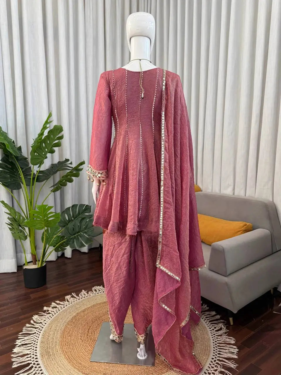 Pink ethnic sharara suit with gold trim, displayed on mannequin for women's festive wear