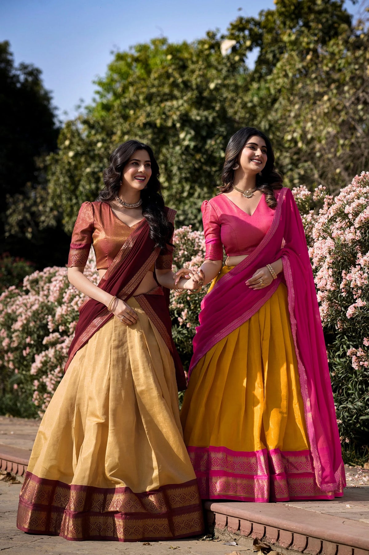 Two models in Kanchipuram half saree lehenga set cream maroon and yellow pink combinations