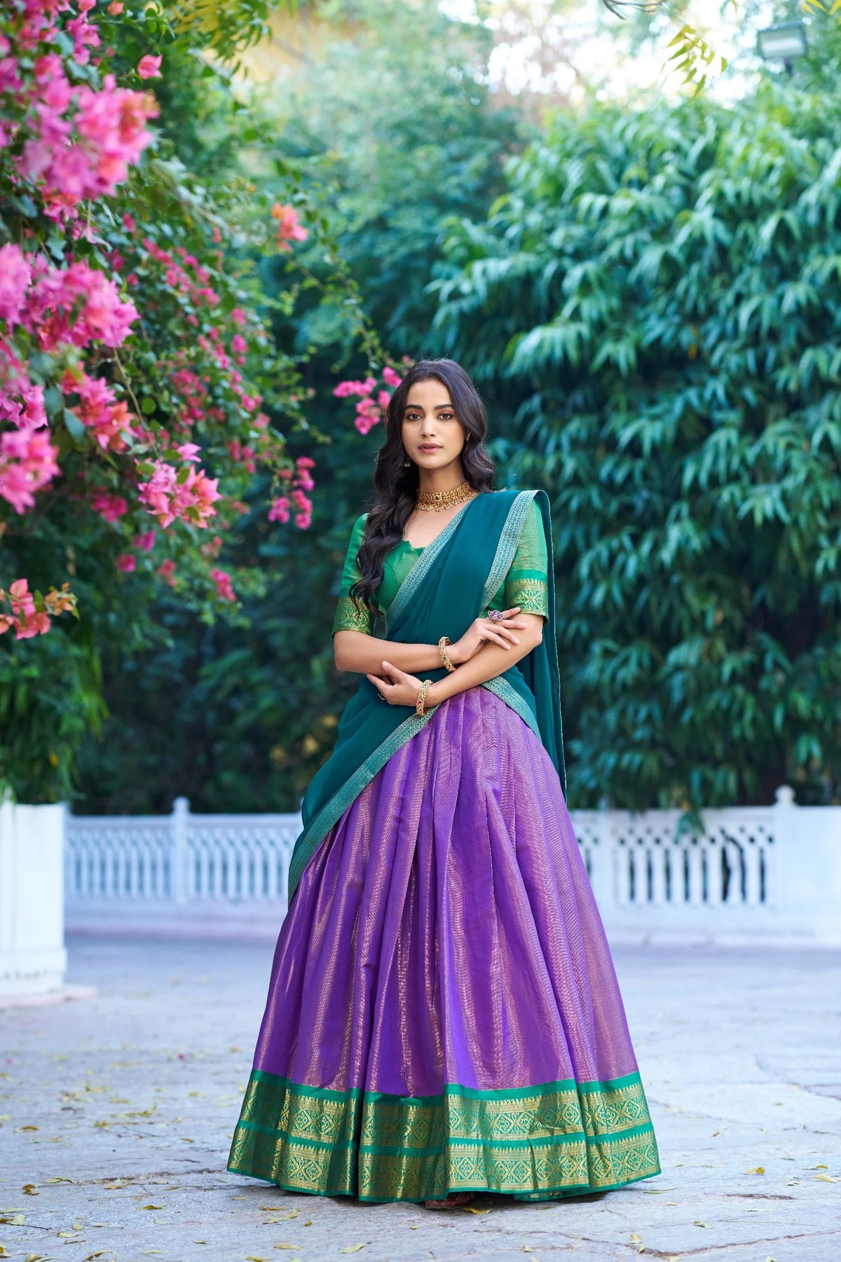 Lime green and pink Kanchipuram half saree lehenga set sitting outdoor view