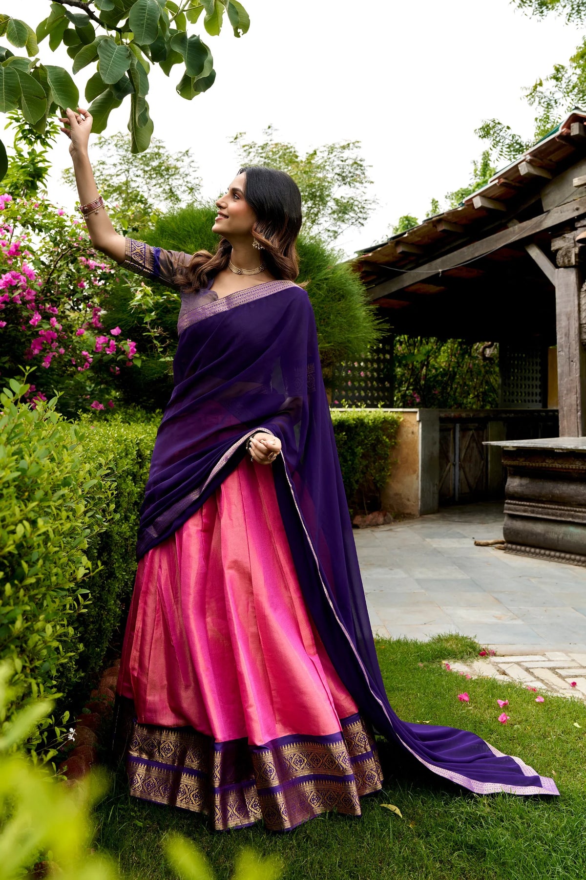 Yellow and red Kanchipuram lehenga set standing outdoor with zari border