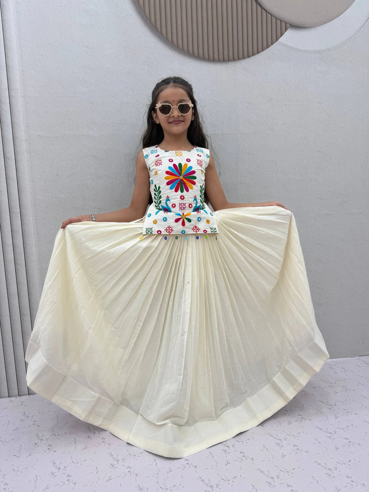 Kids lehenga choli with pleated cream lehenga and bead tassels, twirl view