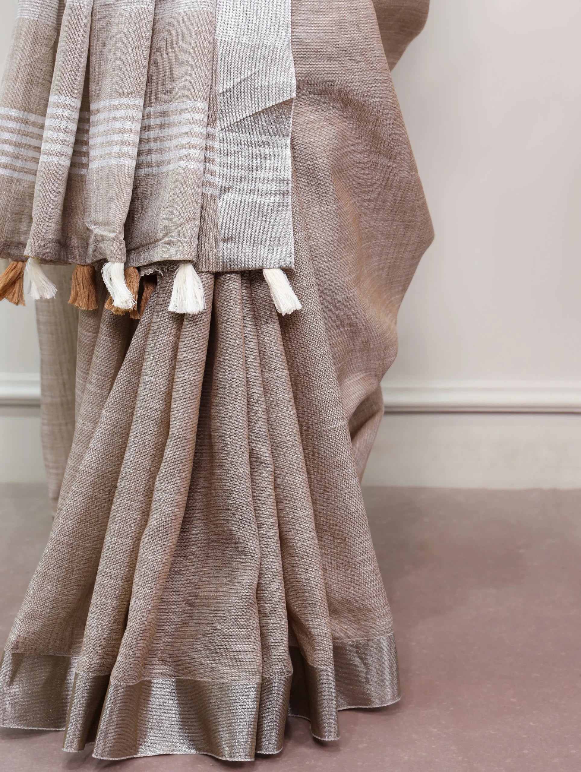 linen saree zari border warm taupe pallu tassels detail