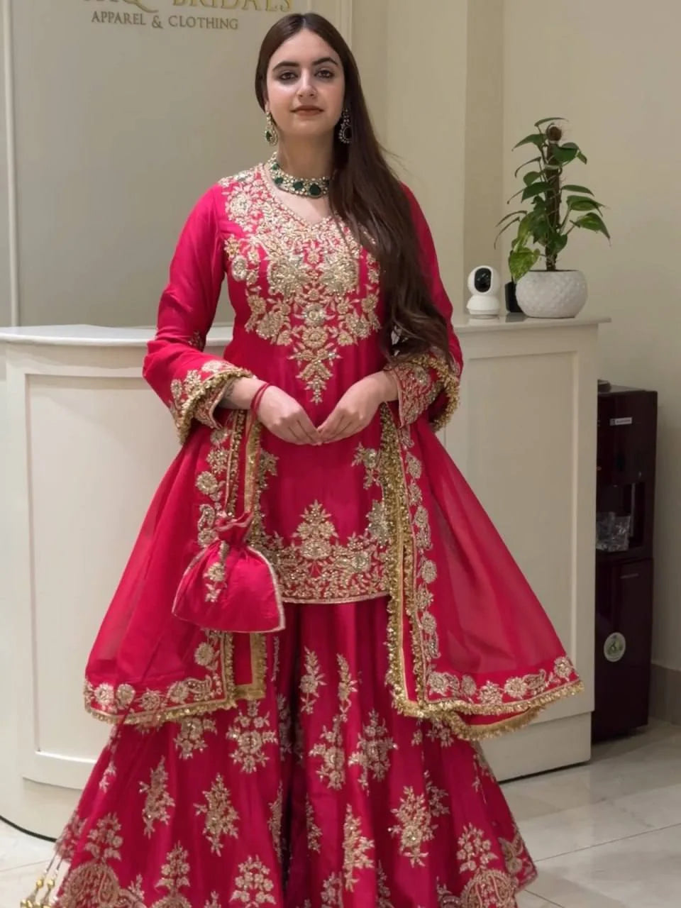 Model wearing magenta chinon silk sharara set with gold thread sequin work