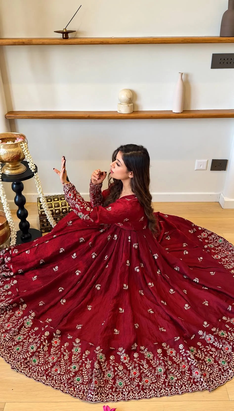 Maroon crush anarkali gown seated showing full flare and gold floral embroidery