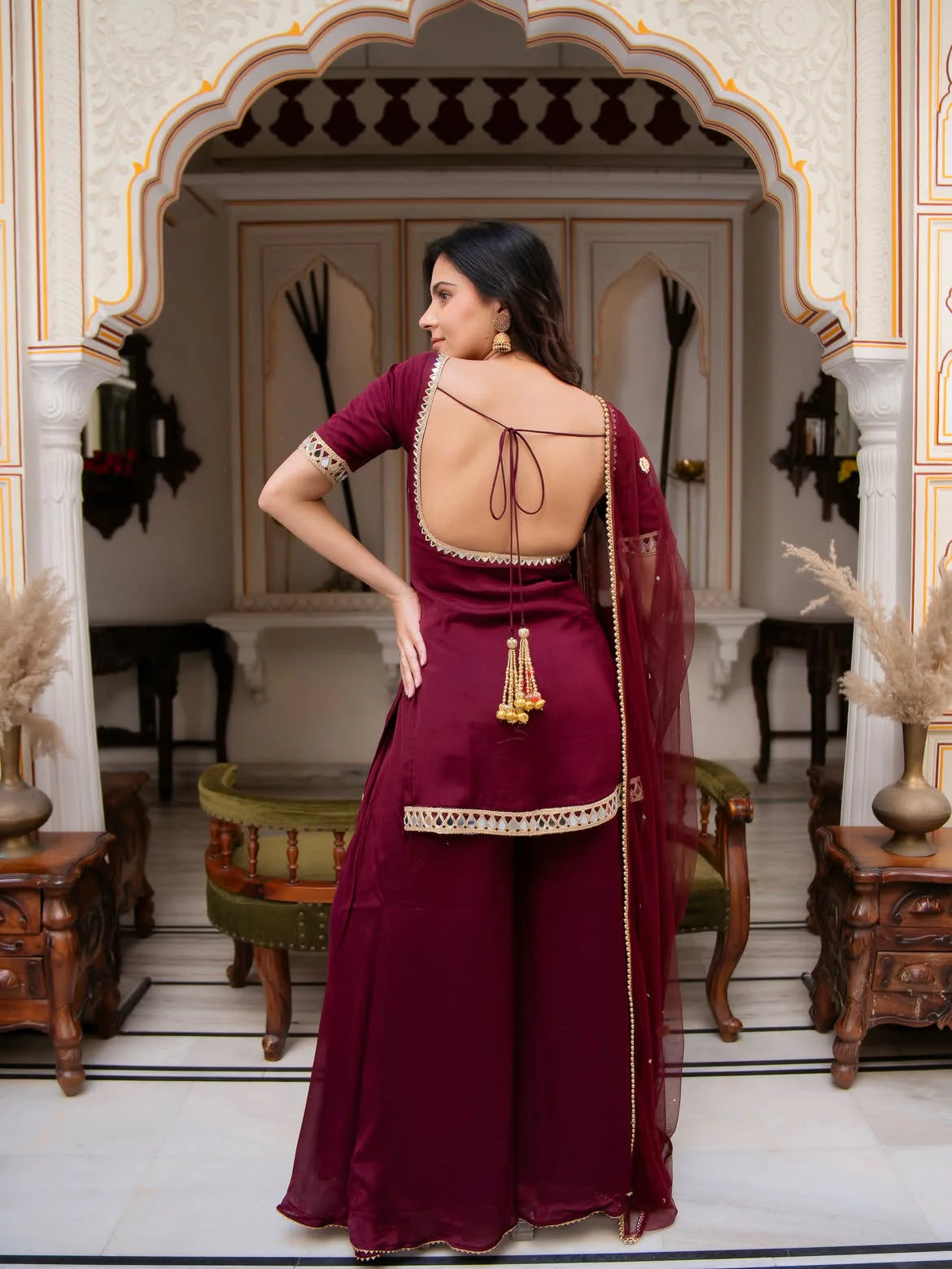 Maroon palazzo set back view — V-backless design with gold tassels and mirror work trim