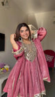 Pink velvet Anarkali gown with mirror work and gold embroidery, perfect for festive occasions