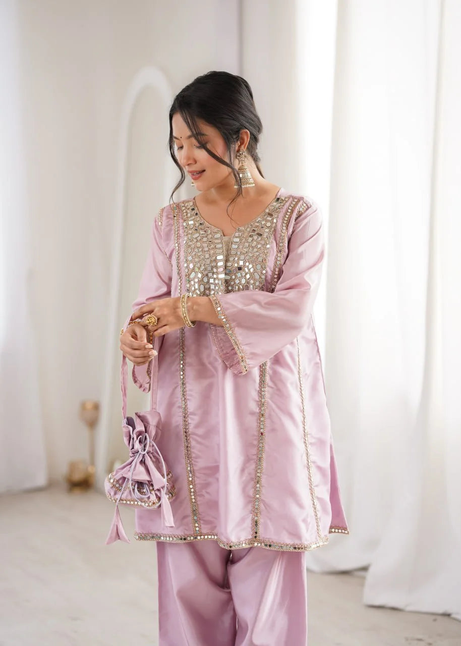 Pink mirror work kurti pant set with matching potli batwa closeup festive