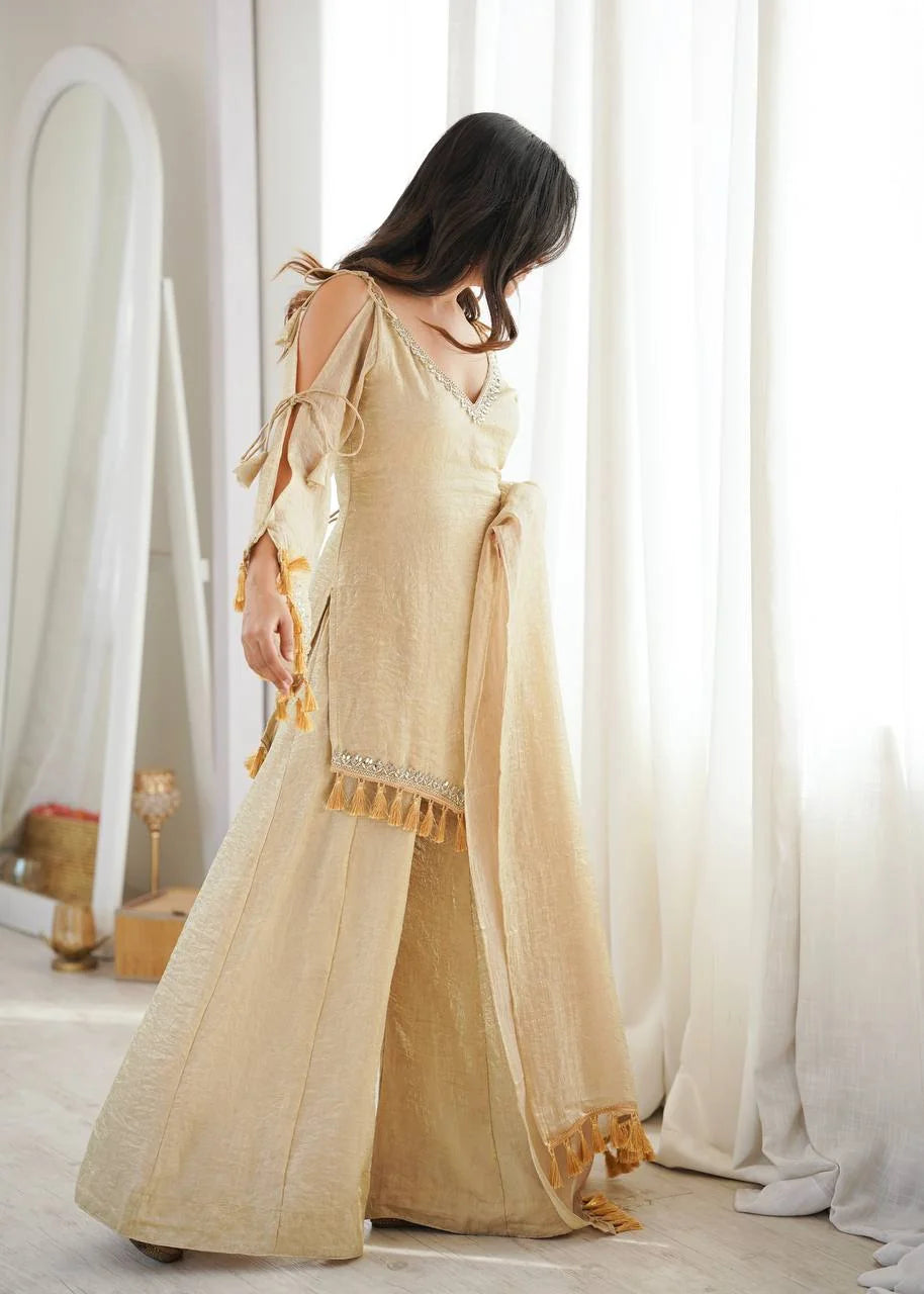 Angle back view of golden Doremon Crush palazzo set showing mirror lace border and tassels