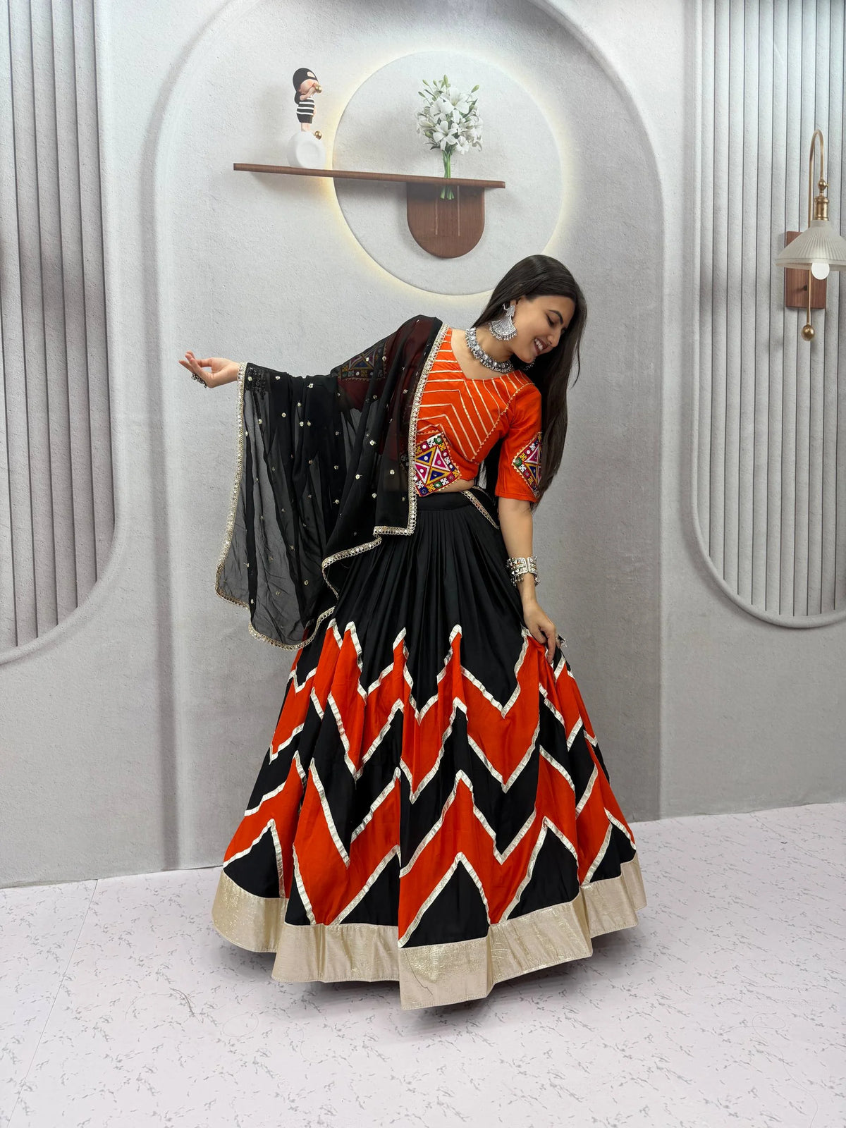 Orange black navratri lehenga choli dancing pose with dupatta