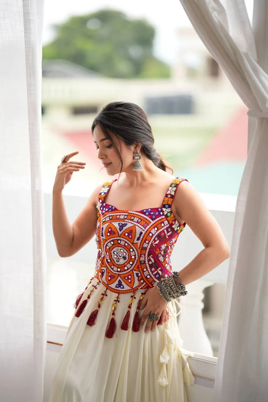 Multicolour Kutchi mirror-work choli of off white navratri chaniya choli with maroon latkan tassels — front detail