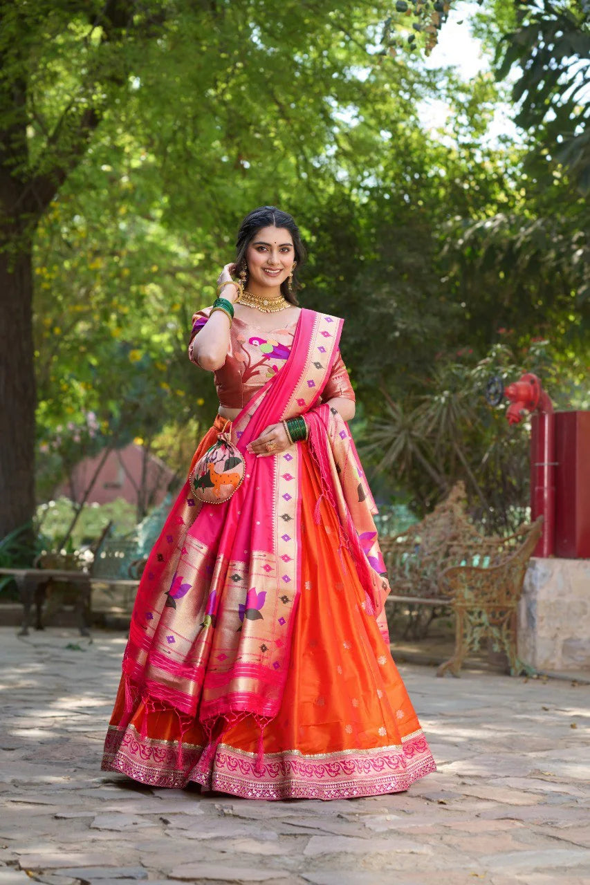 Orange and pink Paithani lehenga set full length standing with batwa potli bag