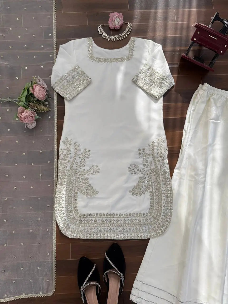 White embroidered outfit with pants on a wooden surface