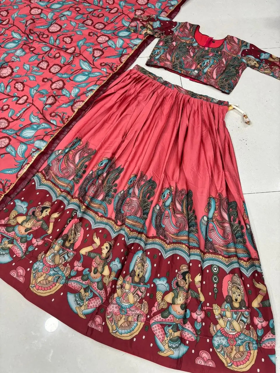 Traditional outfit with a pink and red patterned skirt and blouse on a white background