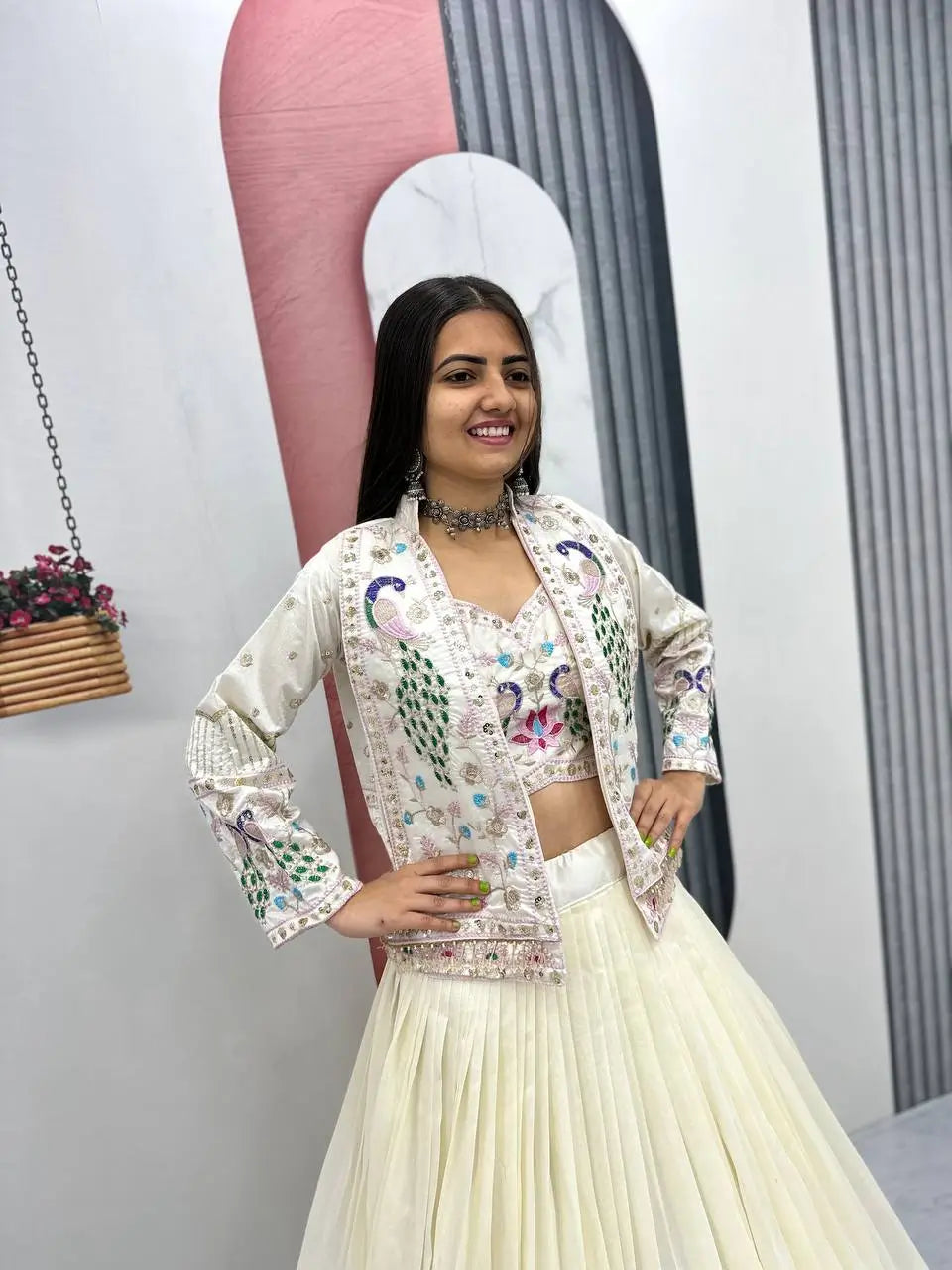 Woman in traditional outfit with floral patterns in a minimal indoor setting