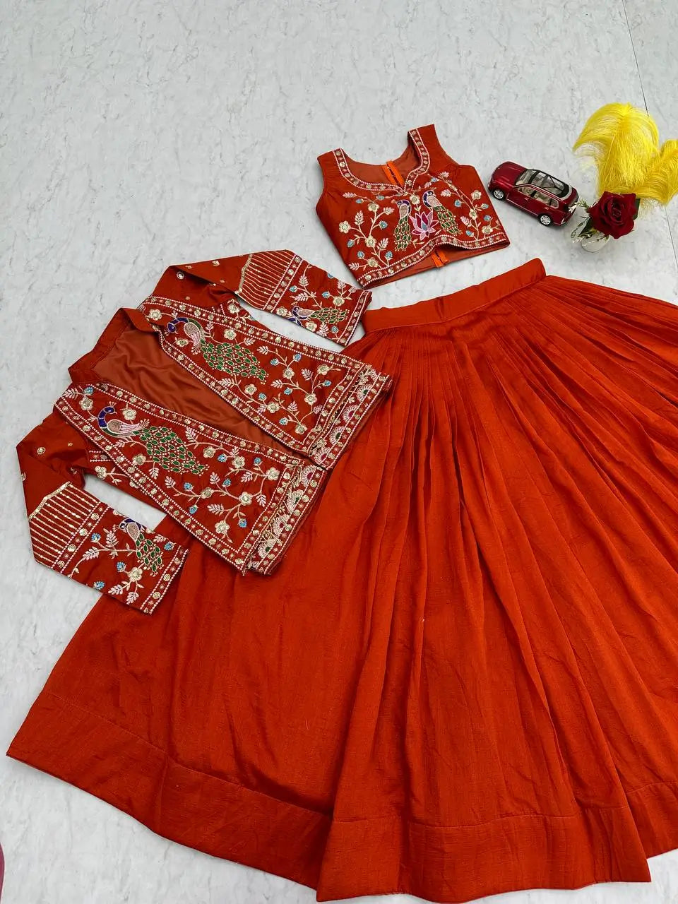 Red traditional outfit with embroidered blouse and skirt on a light gray background