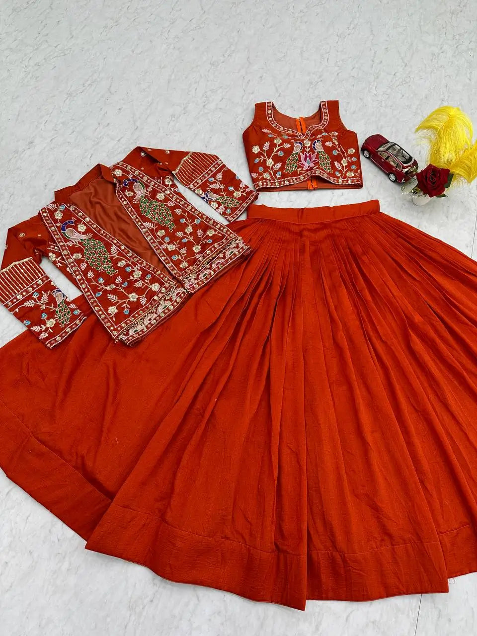 Red traditional outfit with embroidered blouse and skirt on a light gray background