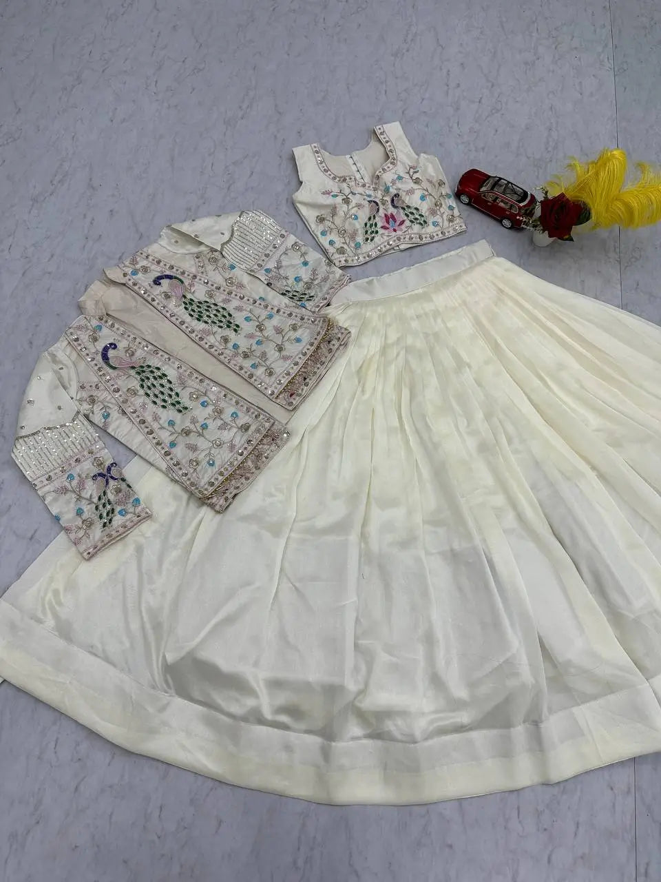 White saree with embroidered blouse pieces on a light gray background
