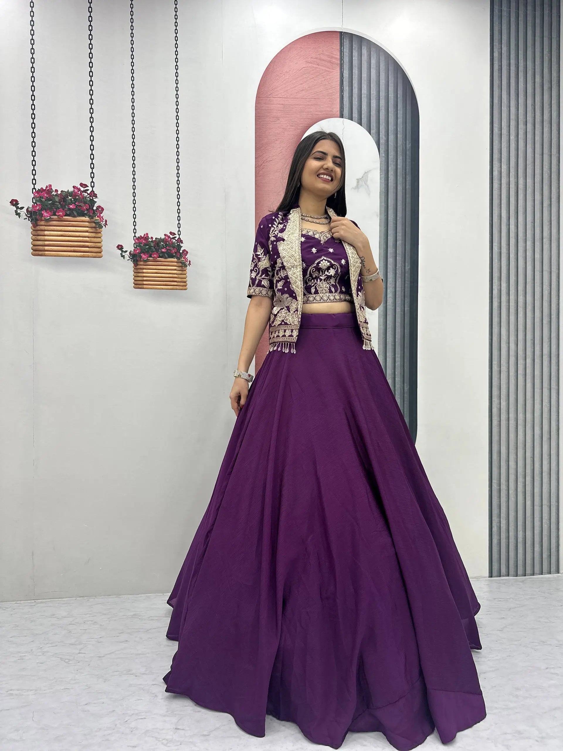 Woman in a purple traditional outfit standing in front of a mirror with decorative elements.
