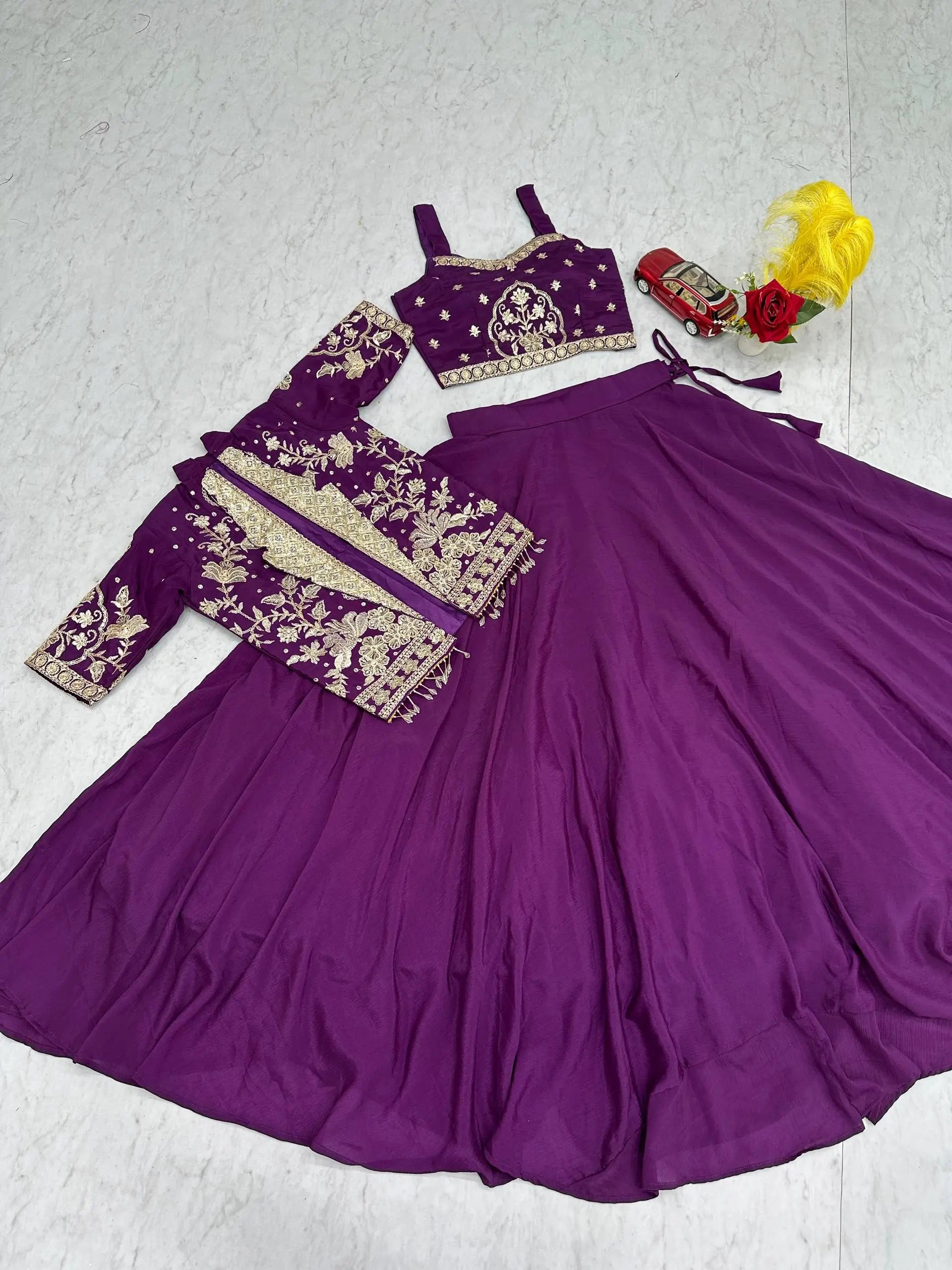 Purple traditional outfit with embroidered blouse and skirt on a white background
