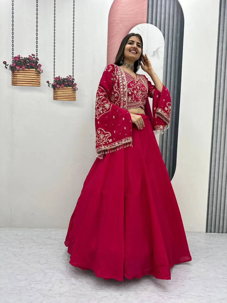 Woman in a red traditional outfit standing in front of a mirror.