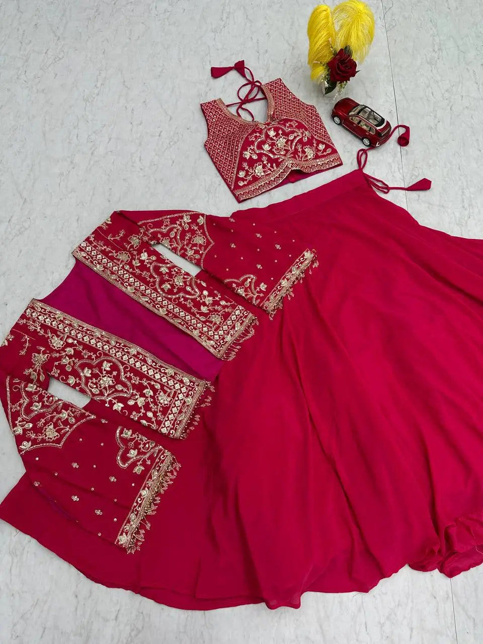 Red traditional outfit with white embroidery on a light gray background