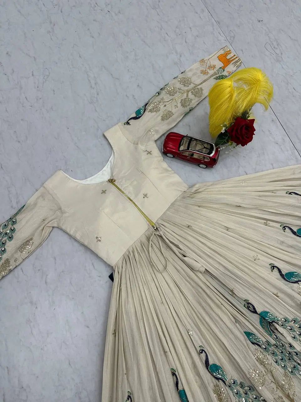 White embroidered dress with decorative elements on a light gray floor.