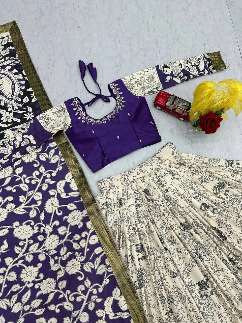 Purple blouse with floral patterns and a matching saree on a light gray background