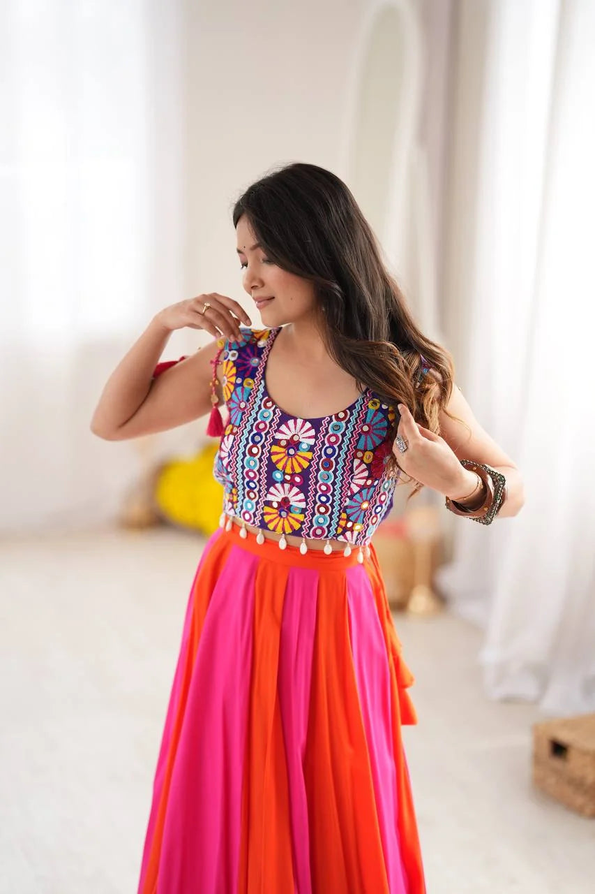 close up of embroidery thread and mirror work on pink orange navratri lehenga choli