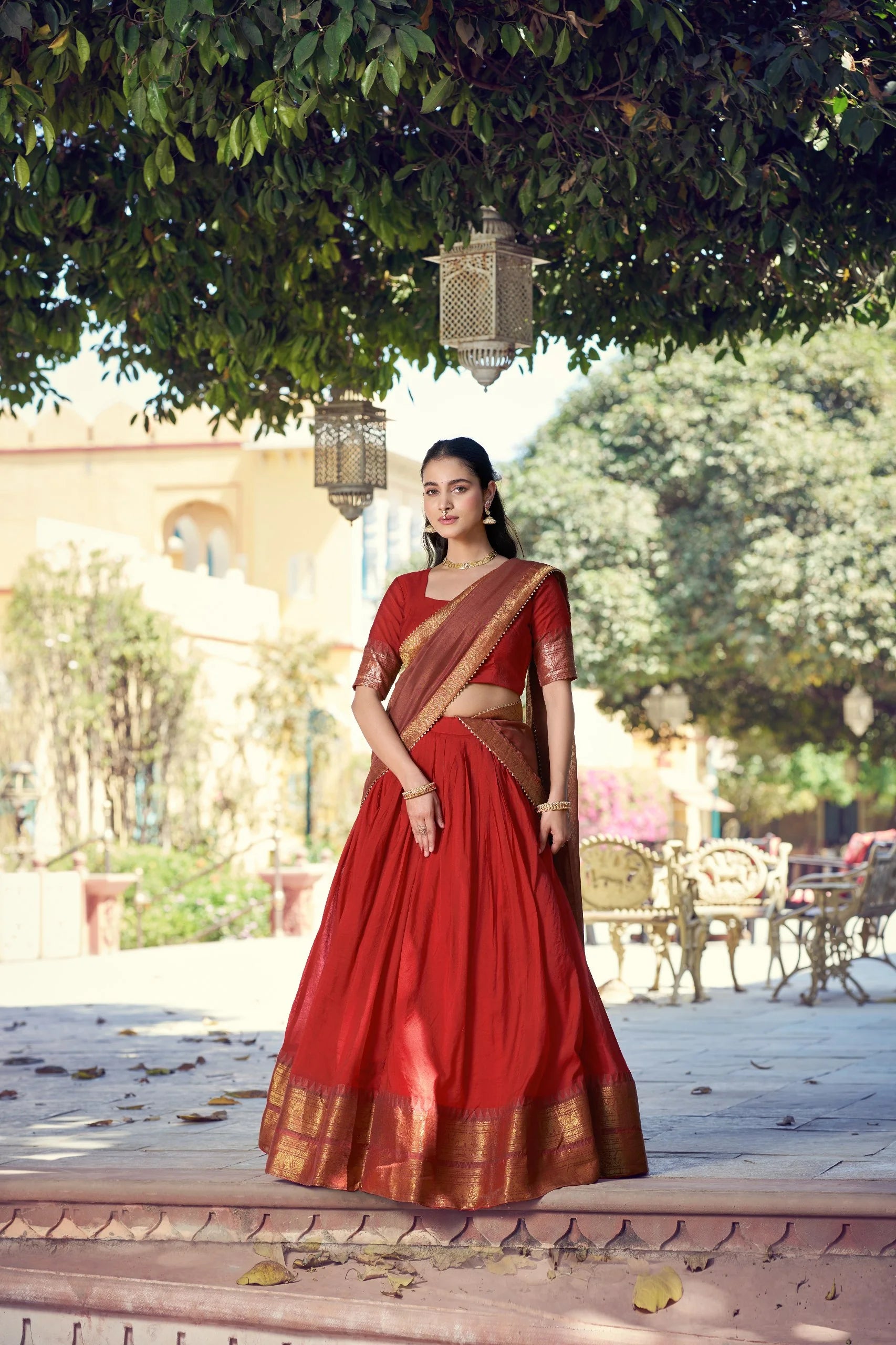 red poly cotton lehenga choli gold zari border standing palace front view