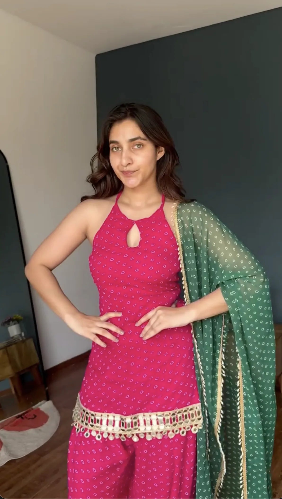 Gold ghungroo bell border on rani pink bandhani kurta patiyala set with bottle green bandhani dupatta — model pose