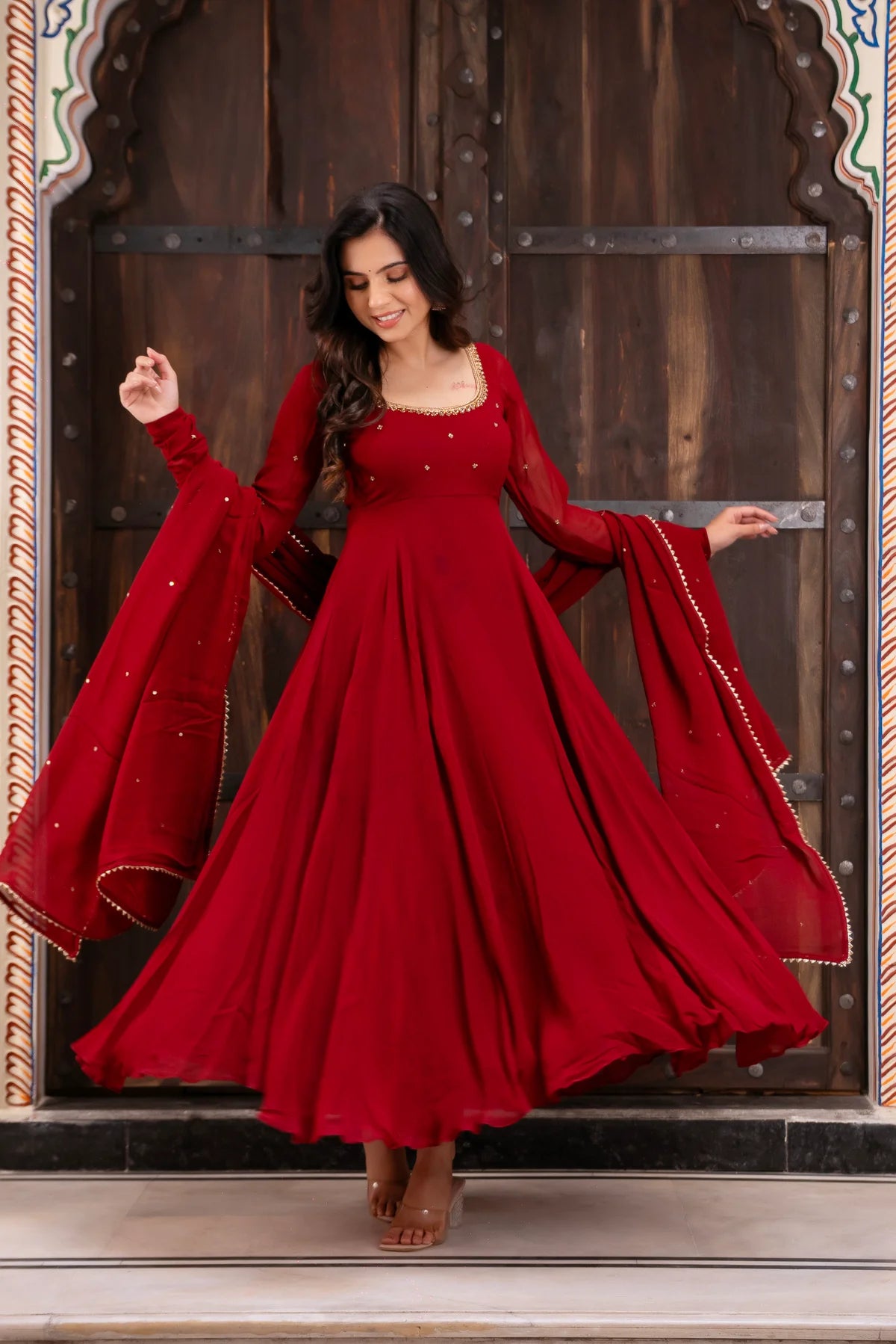Open back with fabric tie and gold jhumka tassel on red anarkali suit – back view