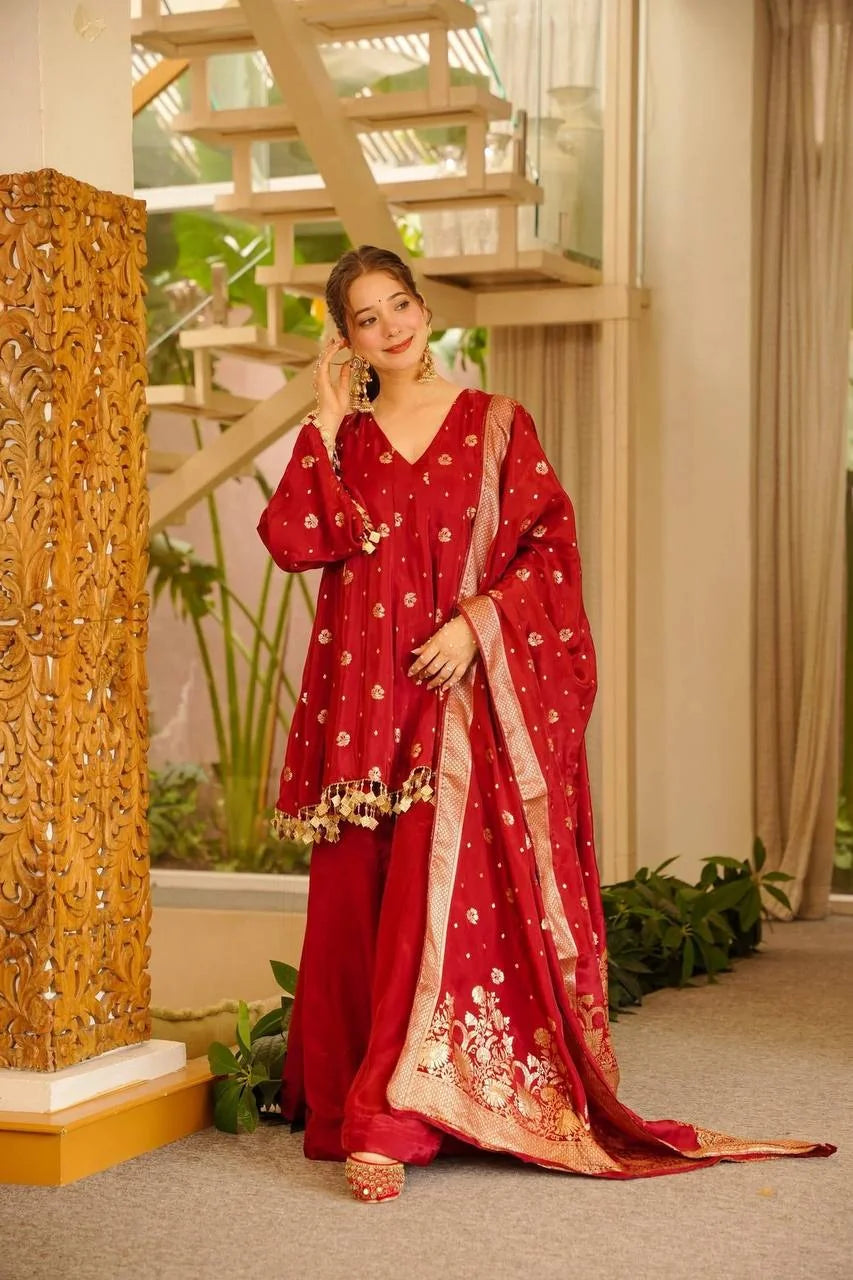 Red satin silk palazzo set with woven dupatta draped over arm – front view