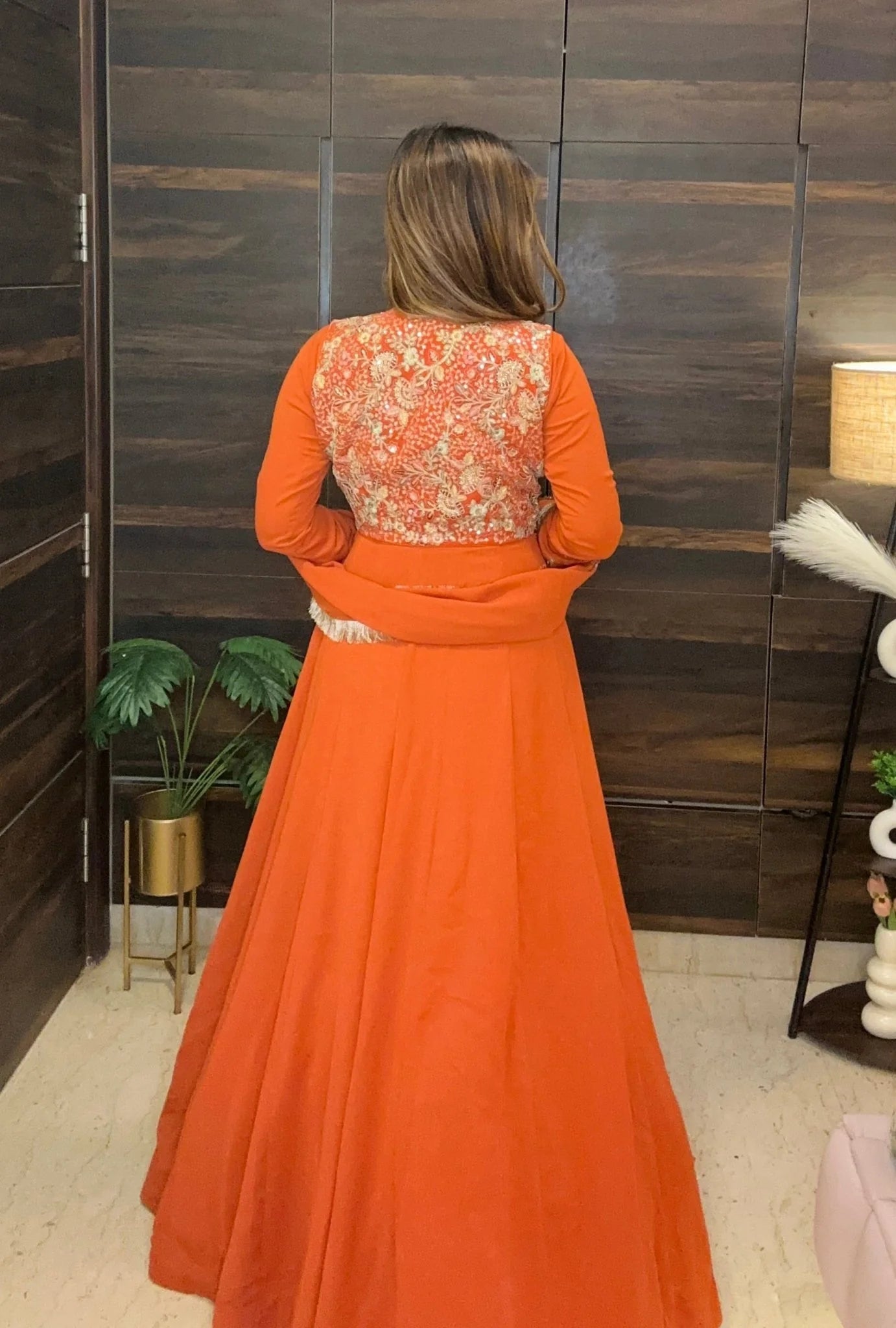 Back view of rust flared anarkali showing dense floral embroidery on yoke