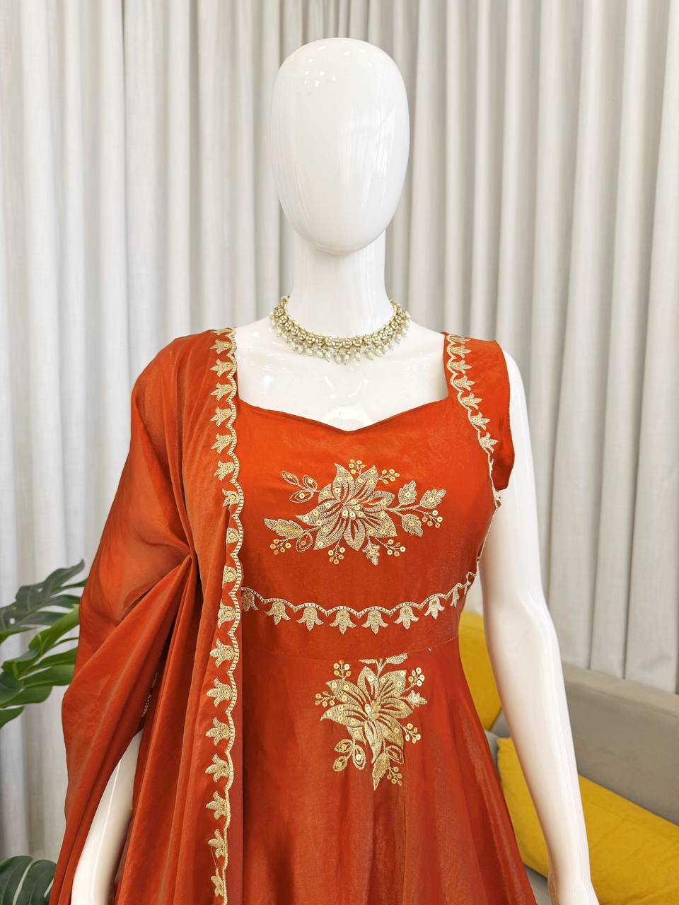 Close-up of rust orange embroidered Anarkali palazzo set with floral gold design details