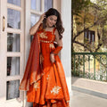 Woman wearing rust orange embroidered Fendy silk Anarkali palazzo set with dupatta twirling outdoor festive wear