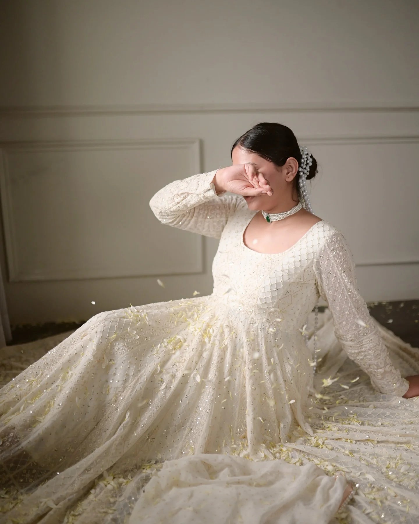 Off white sequin anarkali gown seated pose petal shower