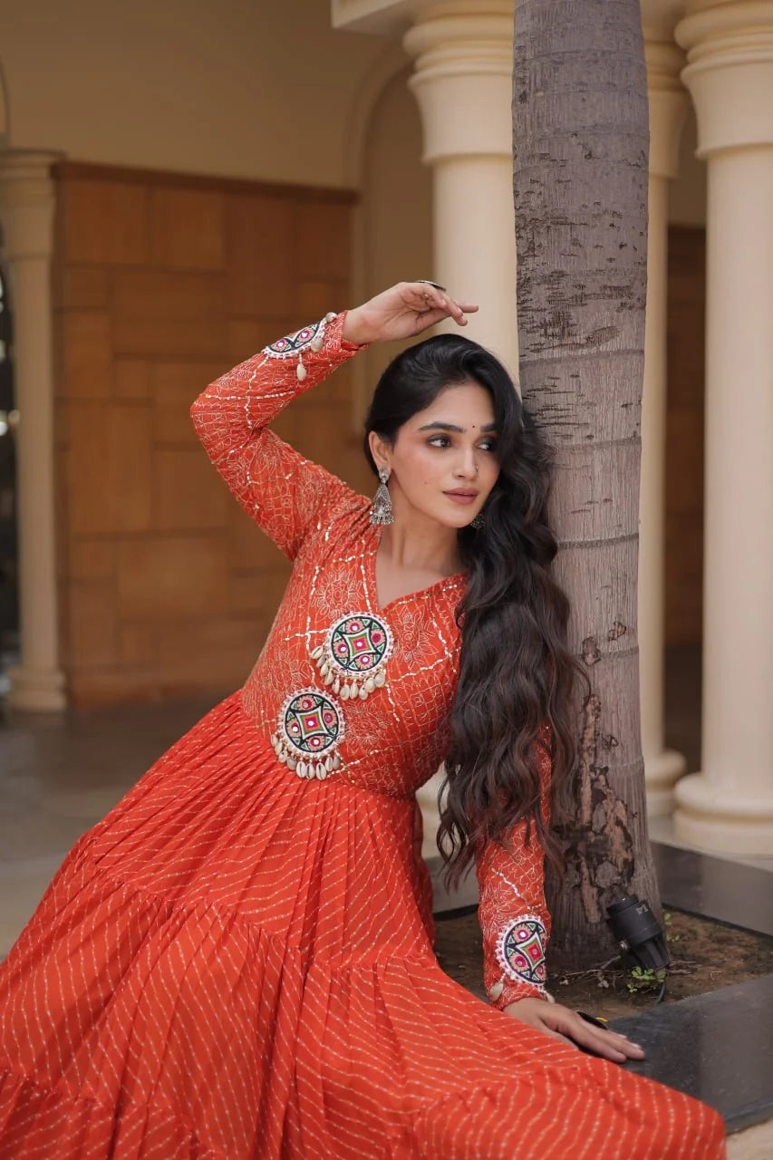 orange sequin leheriya gown seated pose with kutchi mirror work